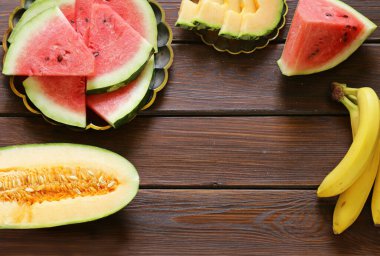 Ahşap masa üzerinde kavun ve karpuz çeşitleri.