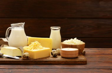 Ahşap bir masada çeşitli süt ürünleri, köy tarzı.