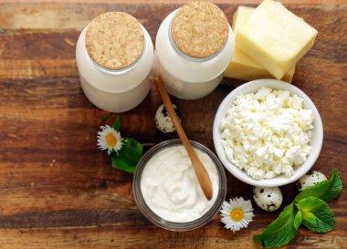 Ahşap bir masada çeşitli süt ürünleri, köy tarzı.