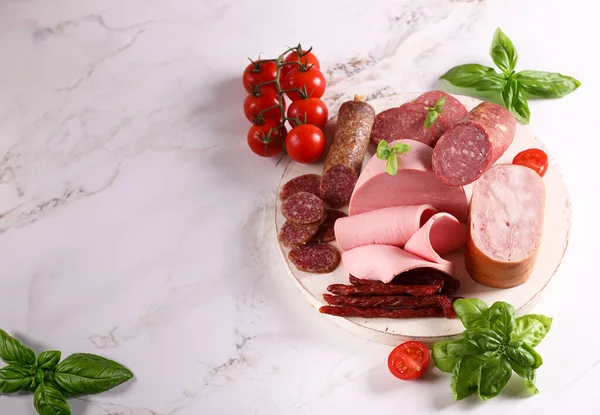 appetizer assortment of deli meats on a wooden board