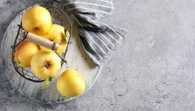 Masadaki sepetteki organik sarı elmalar