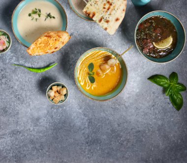 Masanın üzerinde çeşitli çorba kaseleri var.