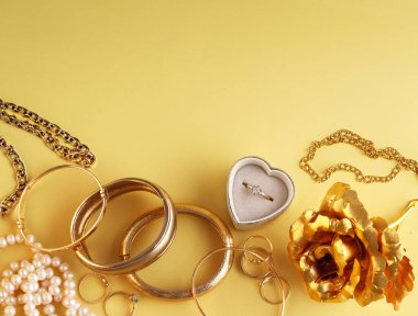 Sarı arka planda altın bilezik yüzüğü.