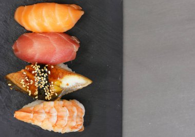 Taş zeminde taze balıklı çeşitli suşiler.