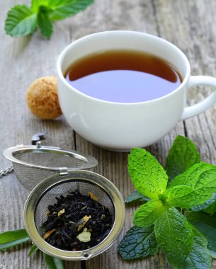 Doğal çay kuru ve tahta bir masada bir fincanda.