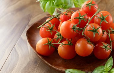 Kiraz domates ve fesleğen ahşap arka plan üzerinde