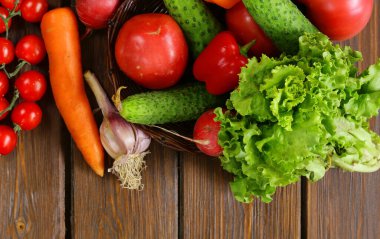 Tahta masadaki organik sebzeler sağlıklı besleniyorlar.