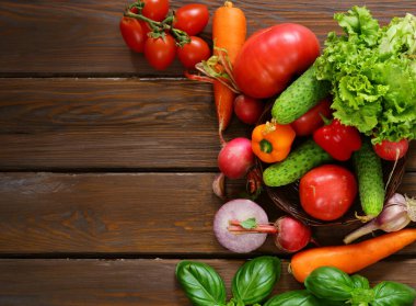 Tahta masadaki organik sebzeler sağlıklı besleniyorlar.