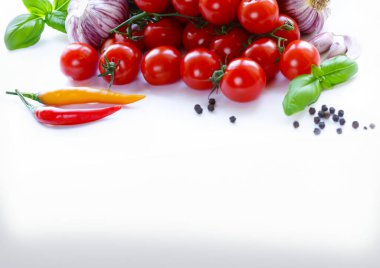 Beyaz arka planda vişneli domates, taze marul ve fesleğen.