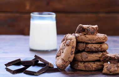 Tahta bir masada çikolata parçacıklı çikolatalı kurabiye.