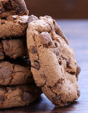 Tahta bir masada çikolata parçacıklı çikolatalı kurabiye.