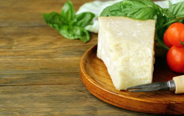 Tahta arka planda taze fesleğenli parmesan peyniri.