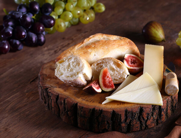 cheese board with baguette and grapes