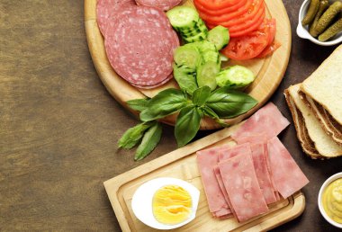 Sandviç malzemeleri ekmek, jambon, sebze ve sos.