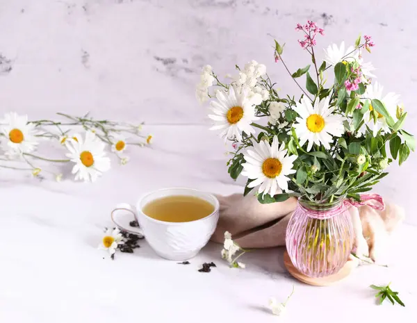 Tasse Kräutertee Und Ein Strauß Kamillenblüten Stockbild