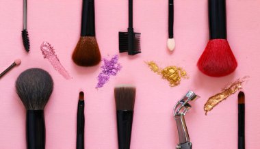 Renkli arka planda makyaj fırçaları ve göz farları