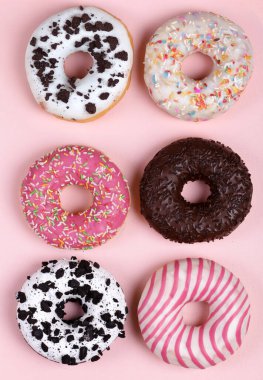 Pembe arka planda renkli jöleli çörekler