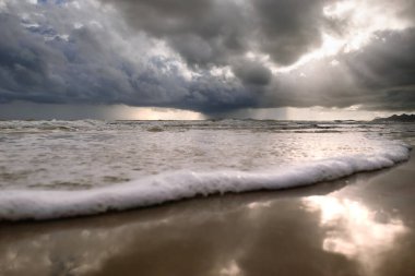 Denizin üzerindeki fırtına bulutları, bulutlar, kara bulutlar, denizde sağanak yağmur ve su yüzeyinde güzel deniz köpüğü..