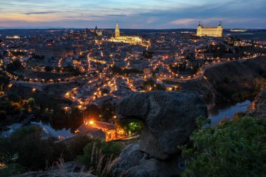 General view of Toledo, Spain, from viewpoint of the valley during the sunset with the street lights on