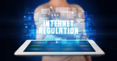 Tablet üzerinde çalışan genç iş adamı dijital işareti gösteriyor: INTERNET Düzenleme