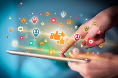 Renkli benzeri simgeler içeren tablet kullanan bir elin yakın plan görüntüsü, sosyal ağ konsepti