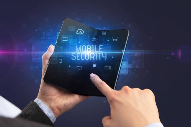 MOBILE GÜVENLİK yazıtlı, siber güvenlik kavramlı katlanabilir bir akıllı telefon tutan iş adamı