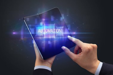 İş adamı elinde katlanabilir bir akıllı telefon tutuyor AUTOMATION yazıtları, yeni teknoloji konsepti