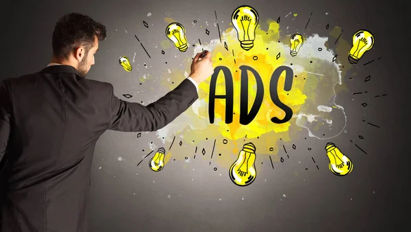 商人画彩色灯泡用Ads缩写 新技术理念 — 图库照片