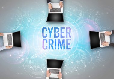 CYBER CRIME insciption, web güvenlik kavramı olan bir dizüstü bilgisayarın önünde bir grup insan