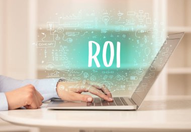 ROI kısaltması, modern teknoloji konsepti ile yeni modern bilgisayar üzerinde çalışan eller