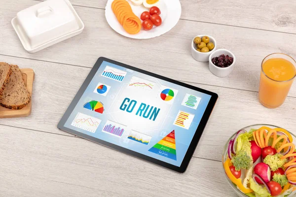 Organic food and tablet pc showing GO RUN inscription, healthy nutrition composition