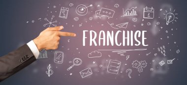 FRANCHISE yazıtına işaret eden kırpılmış elin yakın çekimi, modern iş çözümü kavramı