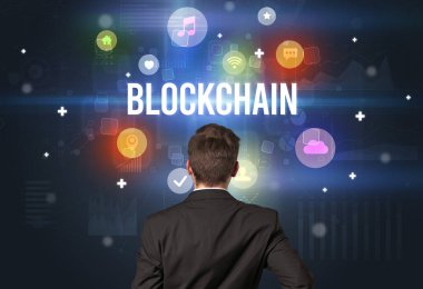 BLOCKCHAIN yazıtlarına sahip bir işadamının arka görünümü, modern teknoloji kavramı