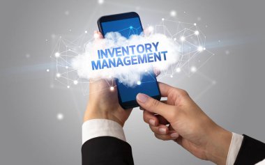 Dişi el akıllı telefona dokunuyor InVENTORY MANAGEMENT yazıtları, bulut iş konsepti