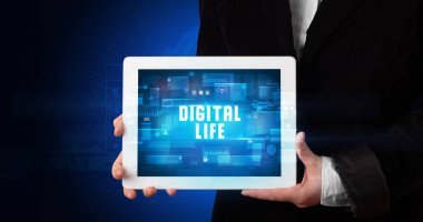 Tablet üzerinde çalışan genç iş adamı dijital işareti gösteriyor: DİGITAL HAYAT