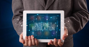 Tablet üzerinde çalışan genç iş adamı dijital işareti gösteriyor: INTERNET Düzenleme