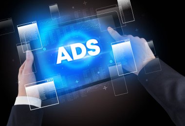 ADS kısaltması, modern teknoloji konsepti olan bir tabletin el ele tutuşması.
