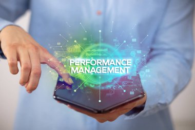 İş adamı katlanabilir bir akıllı telefon tutuyor Performans MANAGEMENT yazıtları, yeni iş konsepti