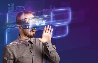 SOFTWARE UPDATE yazıtları ve yeni teknoloji konseptiyle Sanal Gerçeklik gözlüklerine bakan iş adamı
