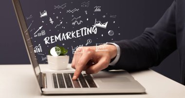 İşadamı, Remarketing yazıtları ve modern iş konseptiyle dizüstü bilgisayarda çalışıyor.