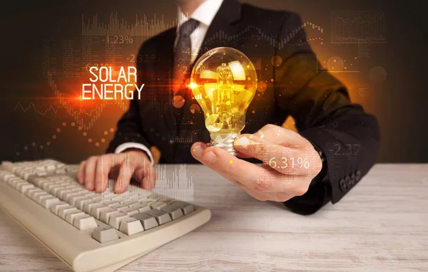 Бизнесмен Держит Лампочку Надписью Solar Energy Концепция Бизнес Технологий — стоковое фото
