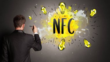 NFC kısaltması ile renkli ampul çizen iş adamı, yeni teknoloji fikri kavramı