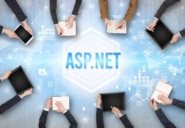 stock image Group of Busy People Working in an Office with ASP.NET inscription, modern technology concept