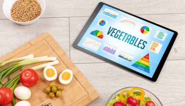 Organik gıda ve tablet bilgisayarı VEGETABLES yazısını, sağlıklı beslenme bileşimini gösteriyor