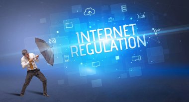 Siber saldırıya karşı şemsiyeyle savunma yapan bir işadamı ve internetteki yazıt, online güvenlik kavramı