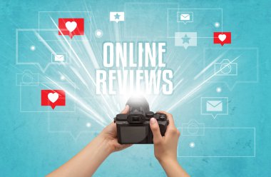 ONLINE REVIEWS yazıtları, sosyal medya kavramı ile fotoğraf çeken bir elin yakın çekimi
