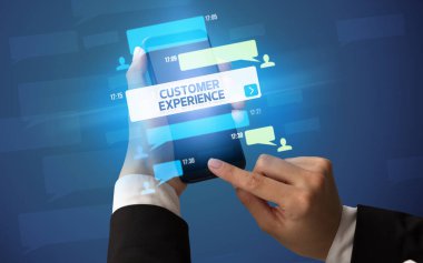 Dişi el, akıllı telefonda CUSTOMER Experience yazısıyla, sosyal ağ konseptiyle yazı yazıyor.
