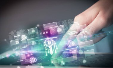 Tablet kullanan bir elin yakın plan görüntüsü, içinden çıkan blok zinciri simgeleri, dijital para birimi kavramı