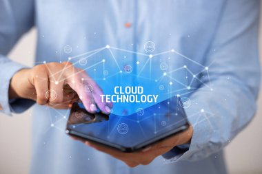 İş adamı CLOUD TEKNOLOJİ yazıtlı katlanabilir bir akıllı telefon tutuyor, yeni teknoloji konsepti