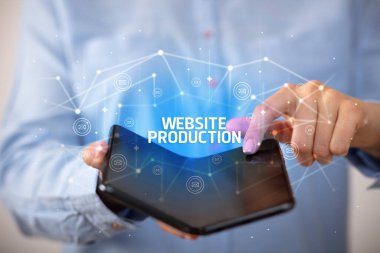 Website Prodüksiyon yazıtları, yeni teknoloji konsepti içeren katlanabilir bir akıllı telefon tutan bir iş adamı.